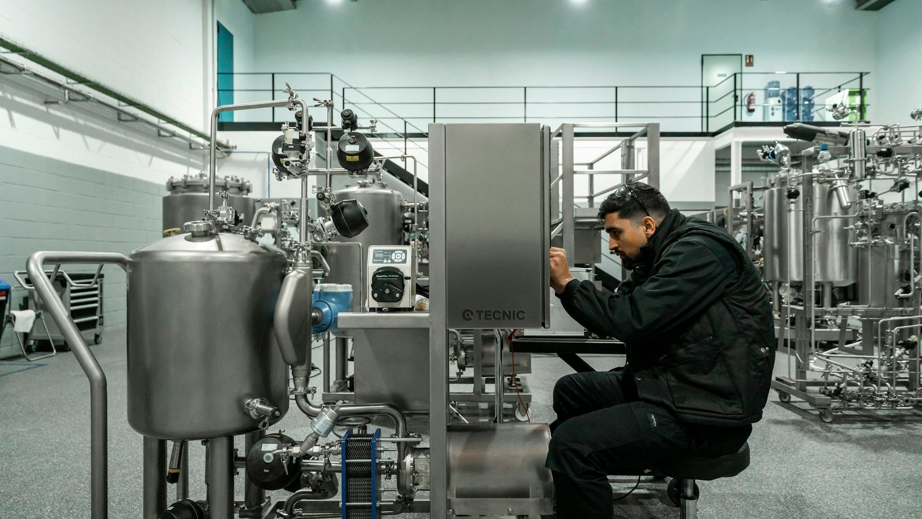 Engineer performing maintenance on stainless steel equipment in a clean facility