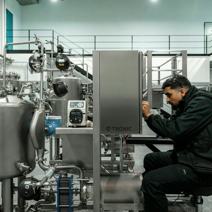 Engineer performing maintenance on stainless steel equipment in a clean facility